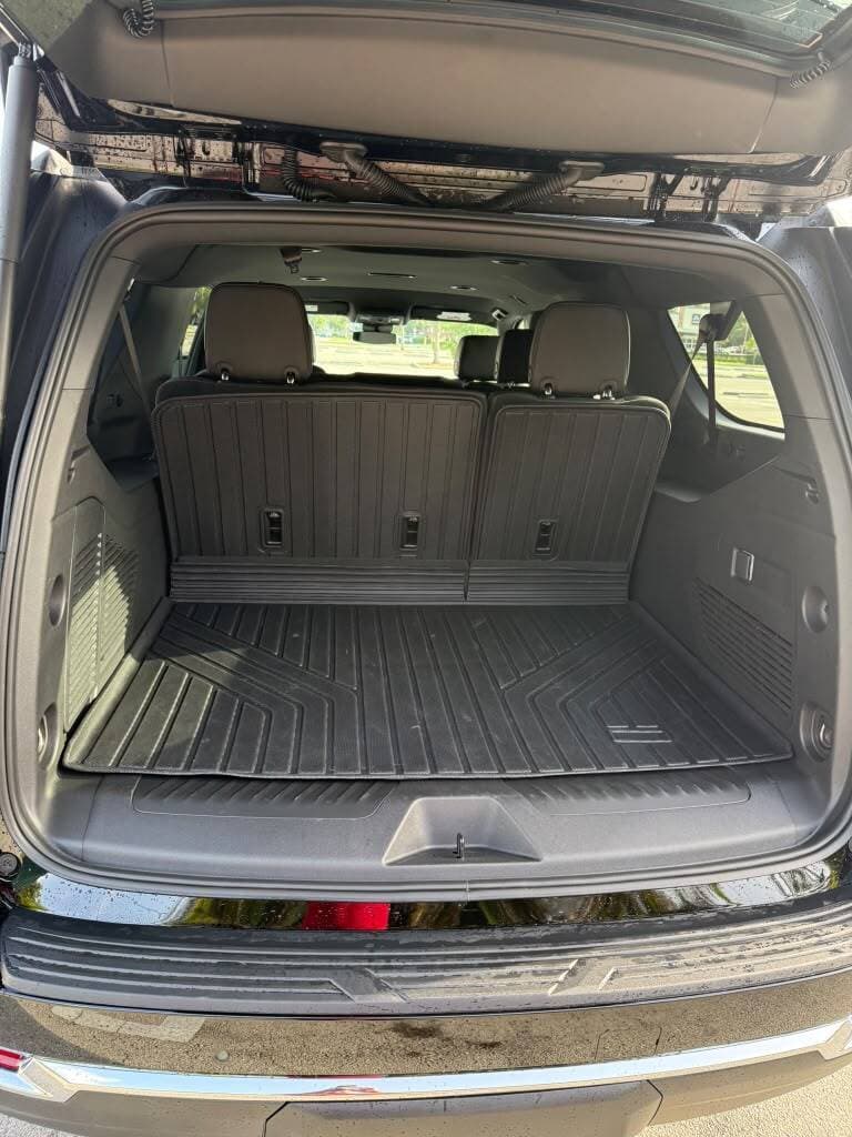 Cargo area of a black Chevrolet Suburban with room for luggage, for suitcases and cruise bags