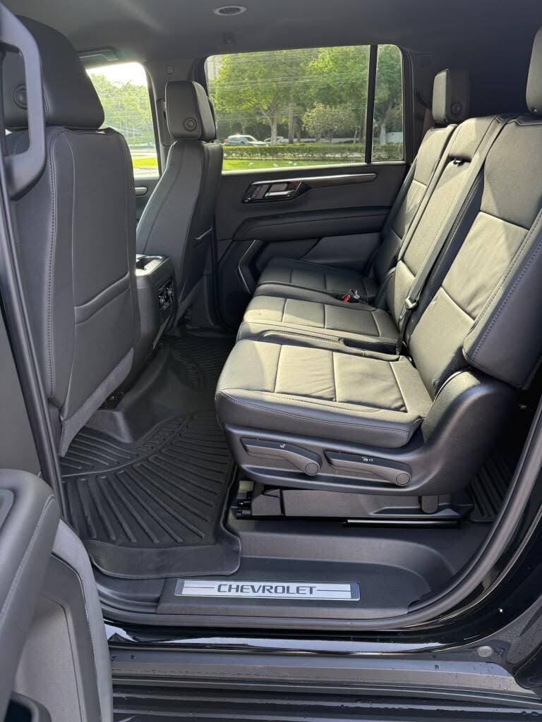 Leather second-row captain's chairs inside a black Chevrolet Suburban